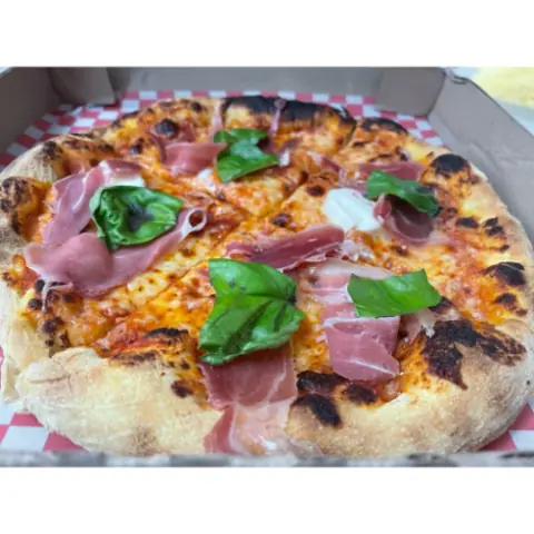 Pizza con prosciutto, mozzarella y albahaca